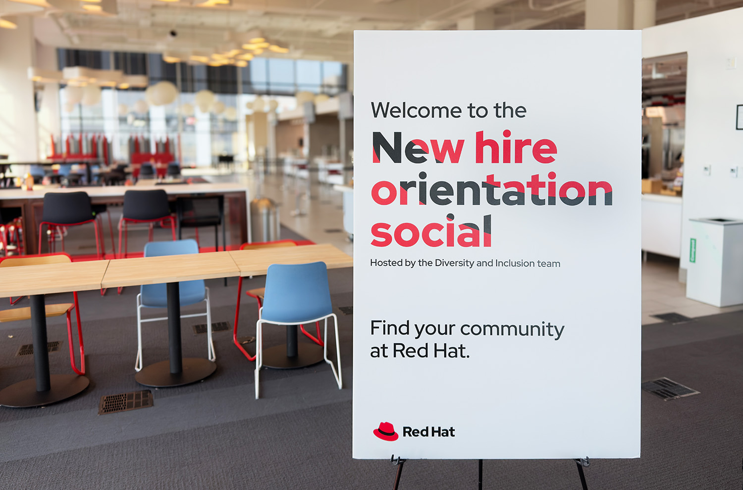 Foto di un cartello promozionale dell'evento New Hire Orientation Social. L'effetto sulla scritta da l'impressione che questa sia sovrapposta all'immagine del cappello che si può scorgere attraverso alle lettere.