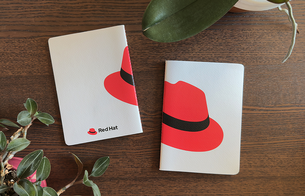 Foto di un quaderno con il cappello stampato sulla copertina. L'immagine del cappello è divisa in due e compare per i 3/4 sulla parte frontale della copertina e per 1/4 sul retro.